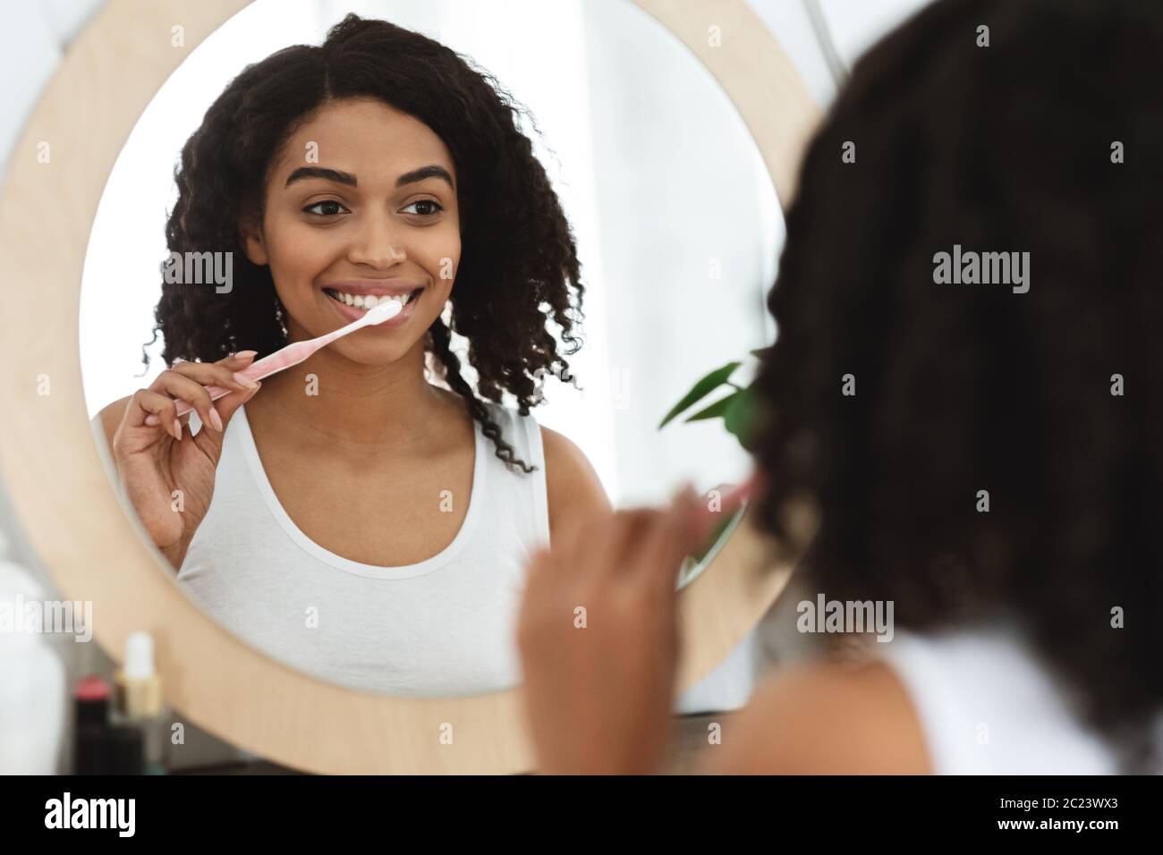 Daily Dental Care. Smiling African Woman Brushing Teeth Near Mirror In Bathroom Stock Photo Alamy