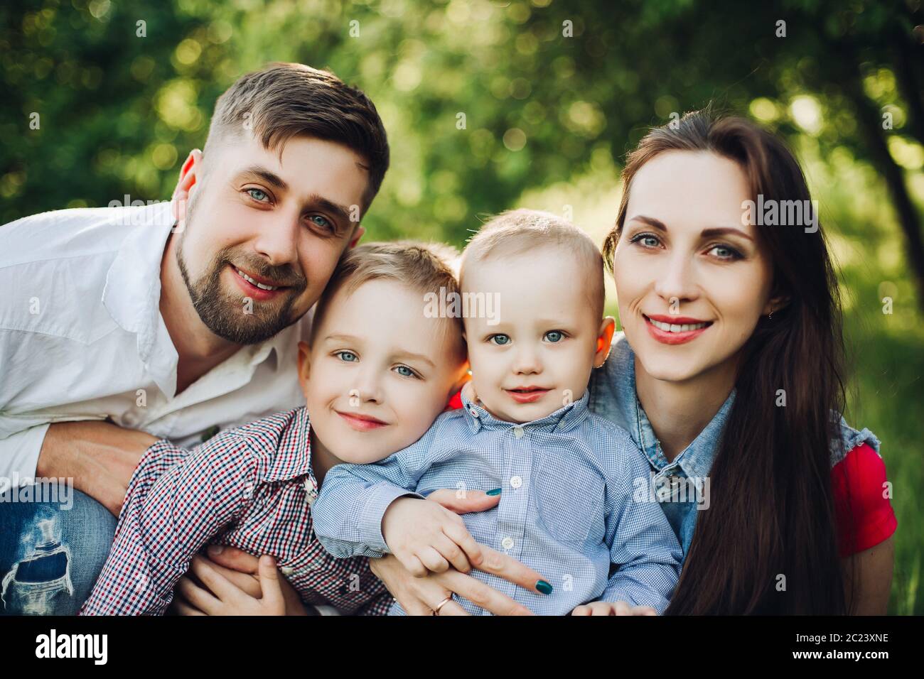 Portrait of young happy family kissing his little son. Stock Photo