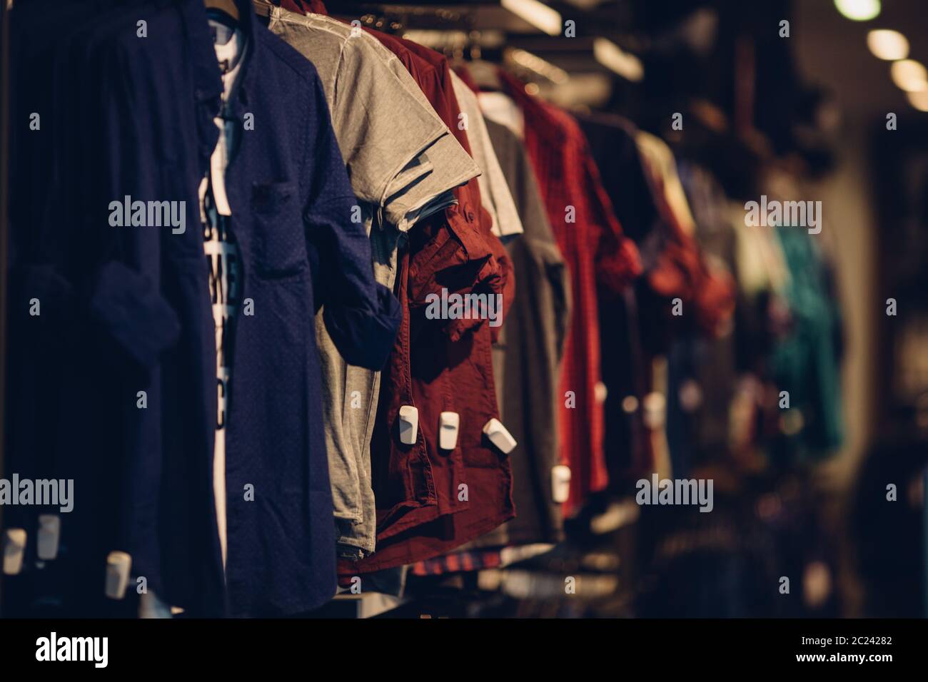 Shirts in men clothing store. Men clothes in shopping mall Stock Photo