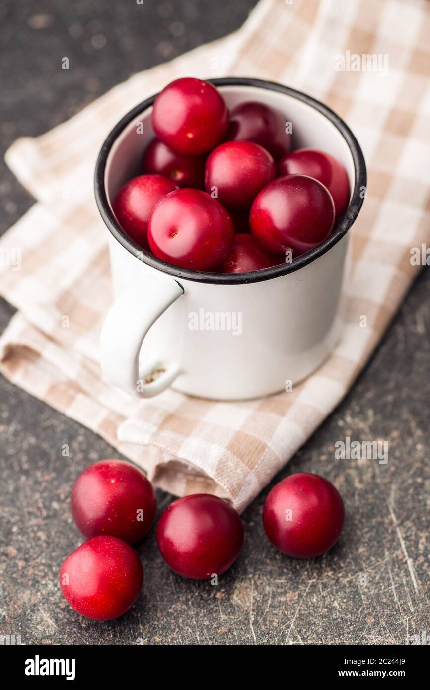 The red cherry plums fruit in mug. Stock Photo