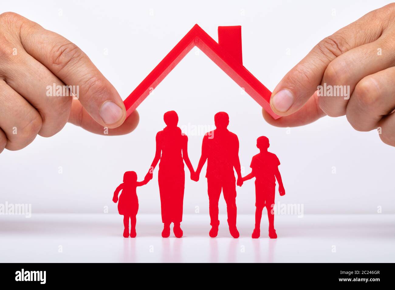 Person Hand Protecting Family Figures With Roof Stock Photo