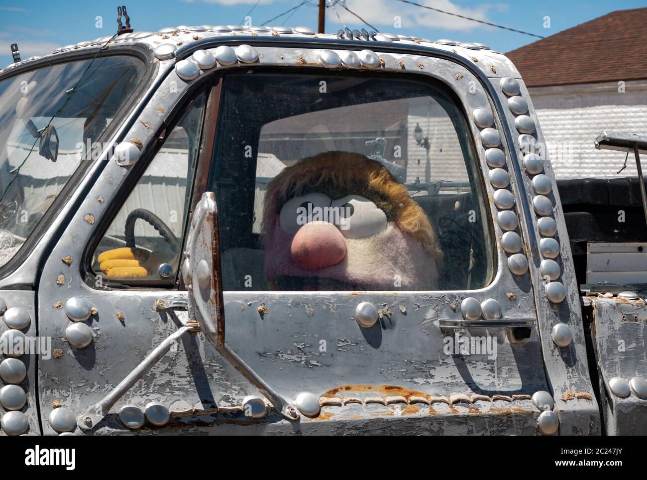 Stuffed toy figure sitting in the cab of a vintage pickup truck Stock Photo