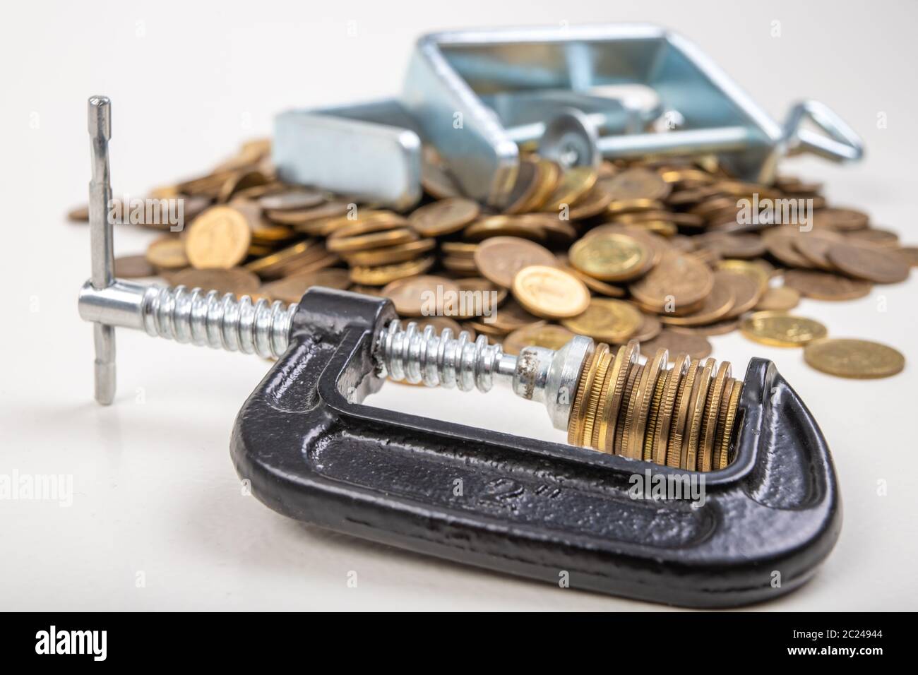 Coins squeezed in a carpenter's clamp. The image of the European ...
