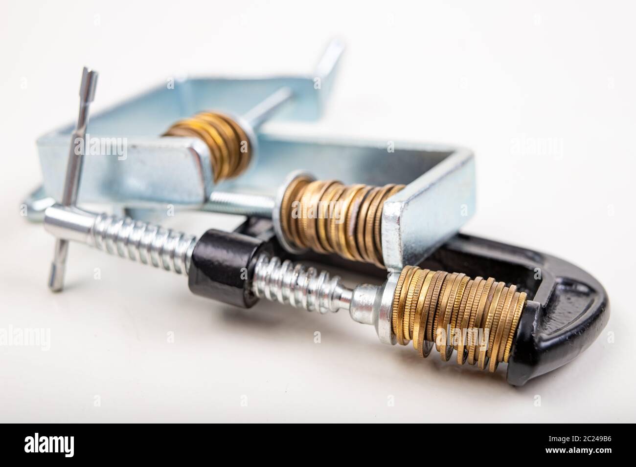 Coins squeezed in a carpenter's clamp. The image of the European ...