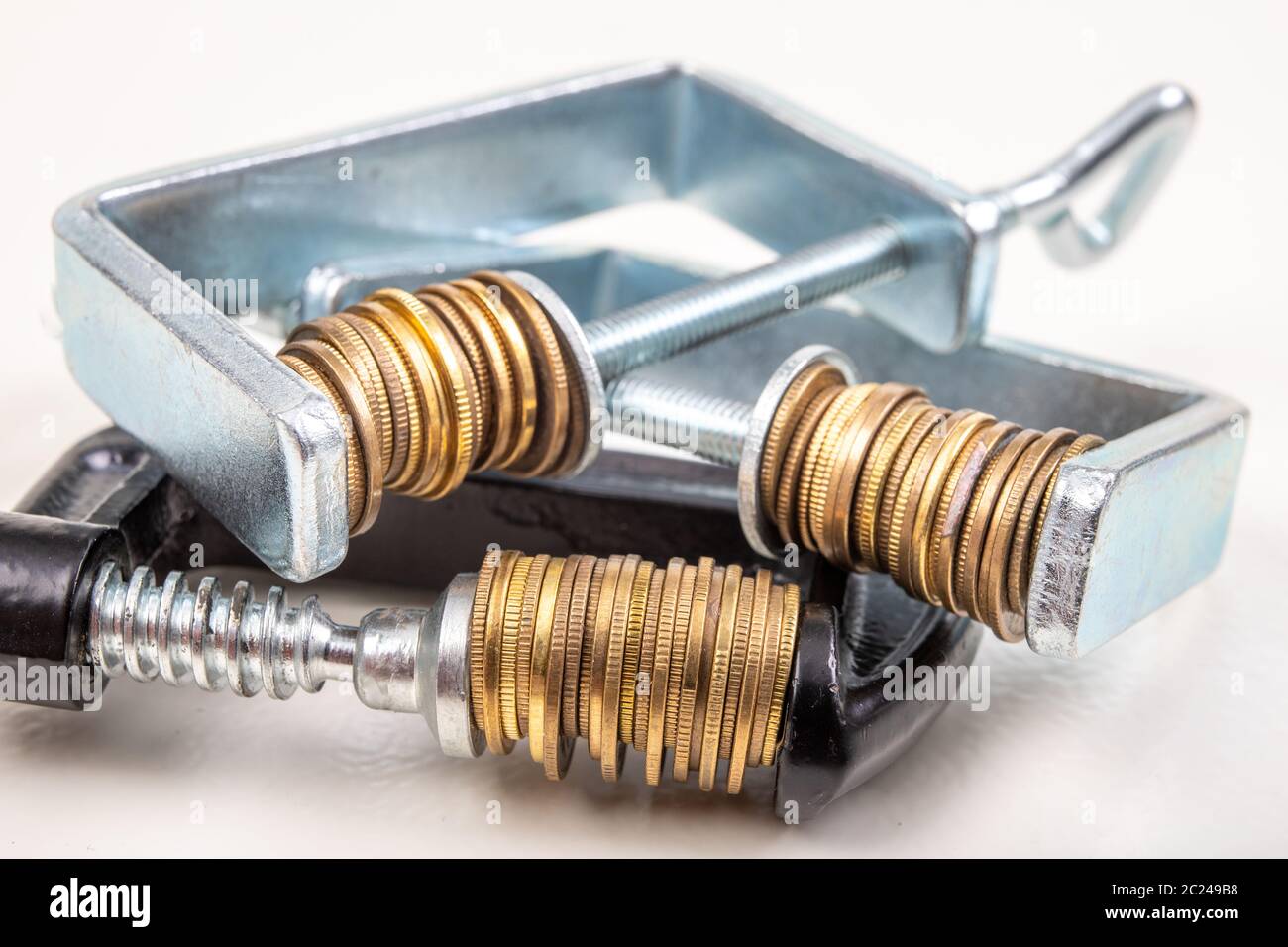 Coins squeezed in a carpenter's clamp. The image of the European ...