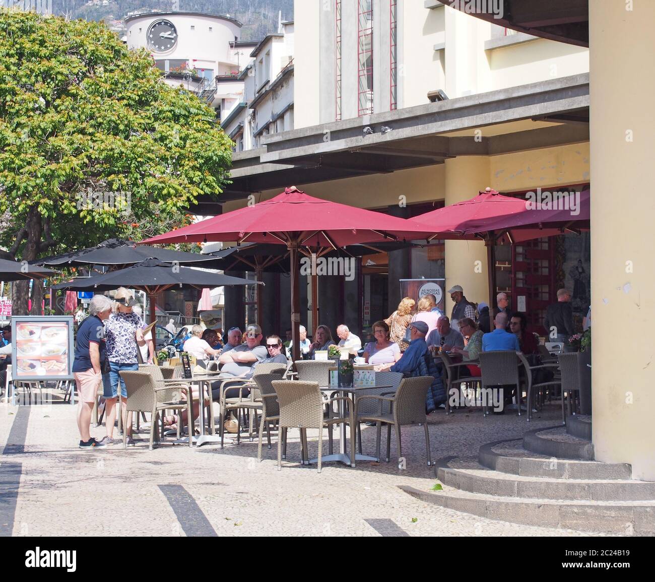 people sitting outside the cafe of the market hall in funchal madeira in bright sunshine Stock Photo