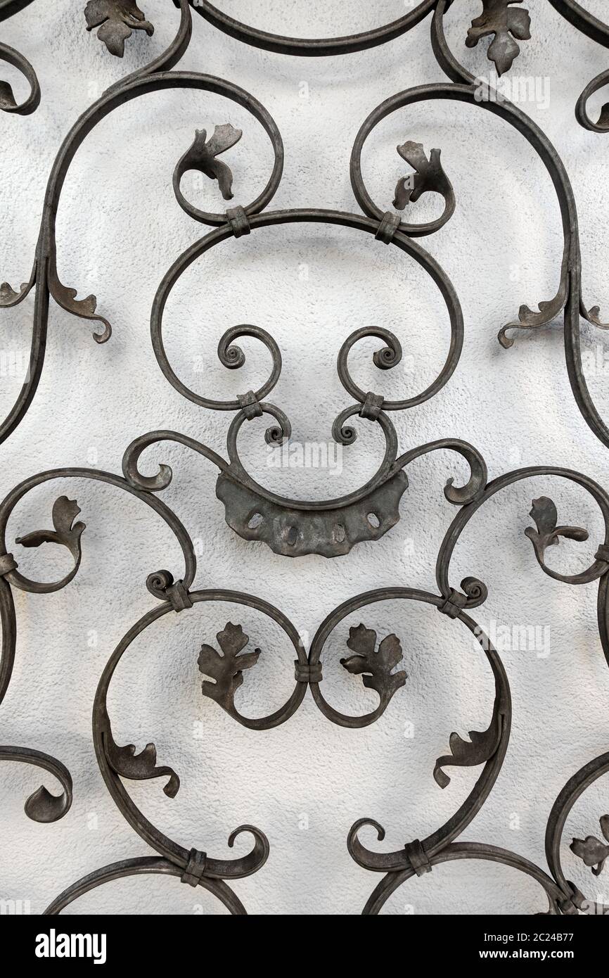 Artful grid made of wrought iron in front of a white wall Stock Photo
