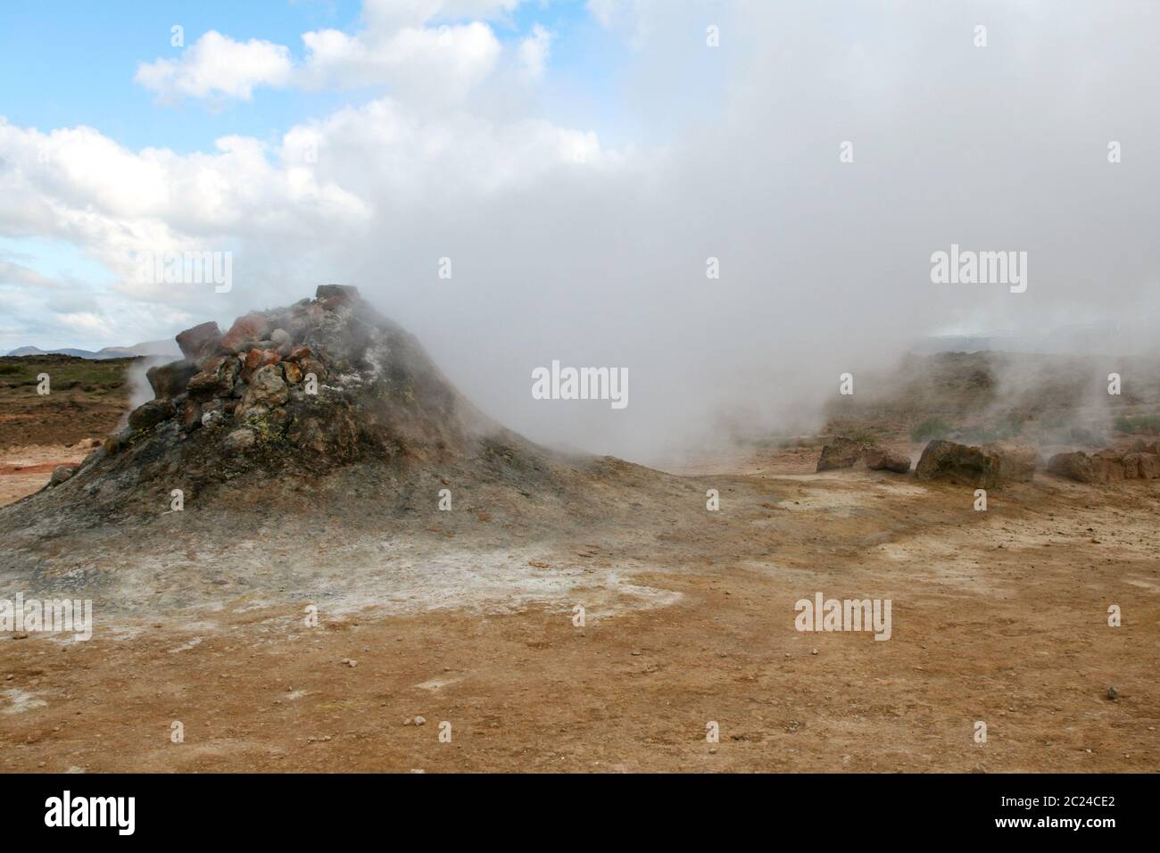 Small cone like volcano spits out steam as a cloud of smoke Stock Photo