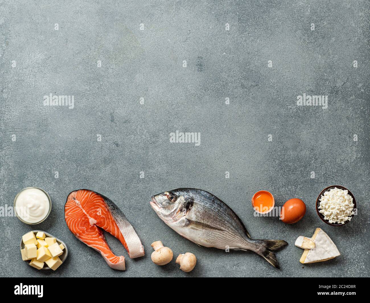 Vaitamin D sources concept with copy space for text. Fish, salmon, dairy products, eggs, mushrooms on gray stone background. Top view or flat lay. Cop Stock Photo