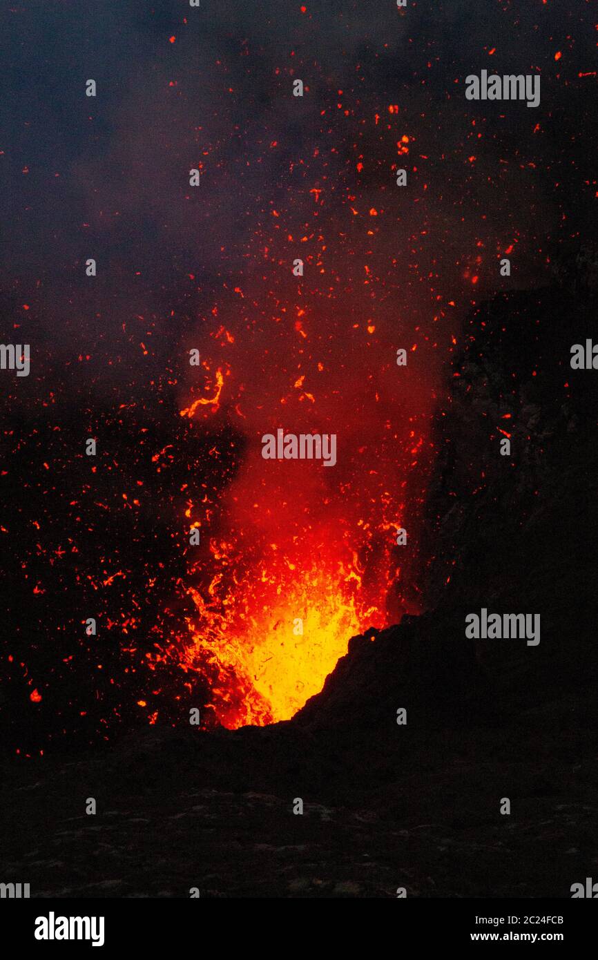 Dangerous fire and lava explosion at volcanic eruption in night Stock Photo