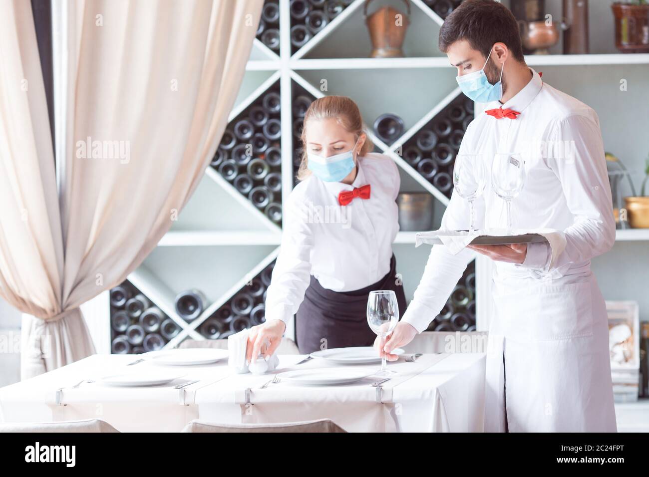 the waiter serves a table in a cafe in a protective mask Stock Photo ...