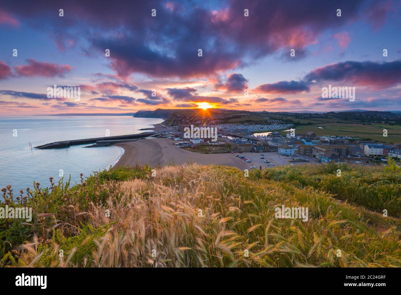 West Bay, Dorset, UK.  16th June 2020.  UK Weather. A dramatic sunset at West Bay in Dorset as the clouds turn red at the end of a warm sunny day.  Picture Credit: Graham Hunt/Alamy Live News Stock Photo