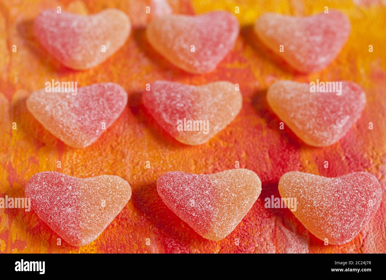 sweet treats, heat shaped fruit gum on orange background Stock Photo