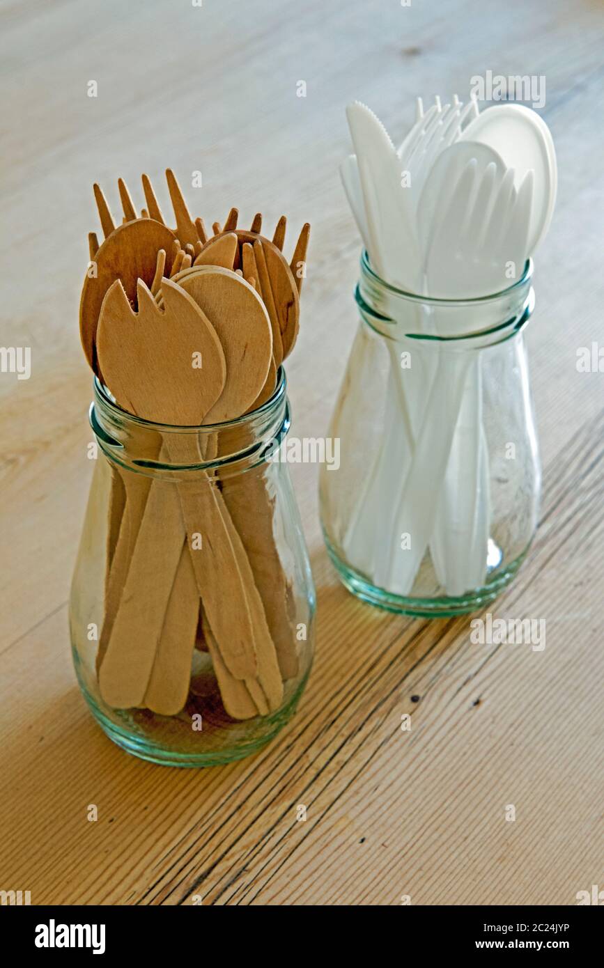 Wooden and reused plastic cutlery in glass jars on table.  Zero waste concept Stock Photo