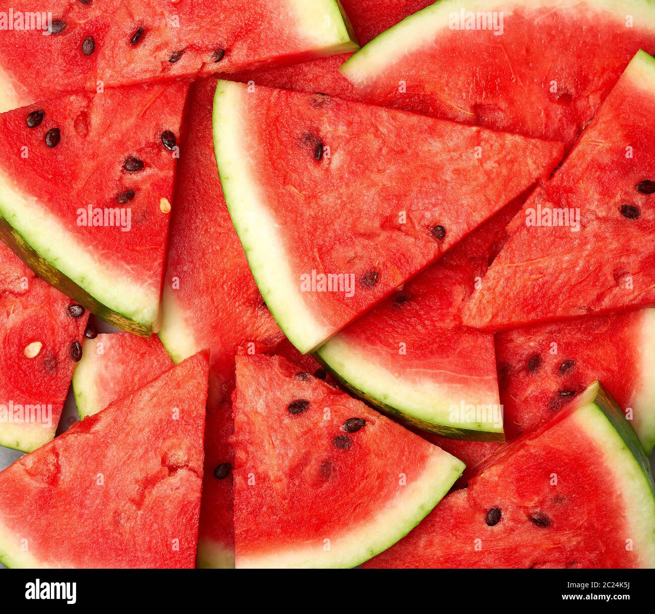 sliced triangular slices of ripe red watermelon with brown seeds ...