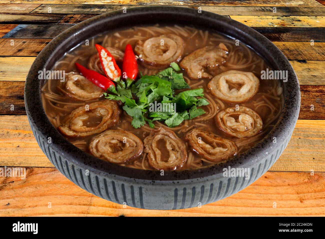 The brown color vermicelli with pork intestine on black bowl isolated