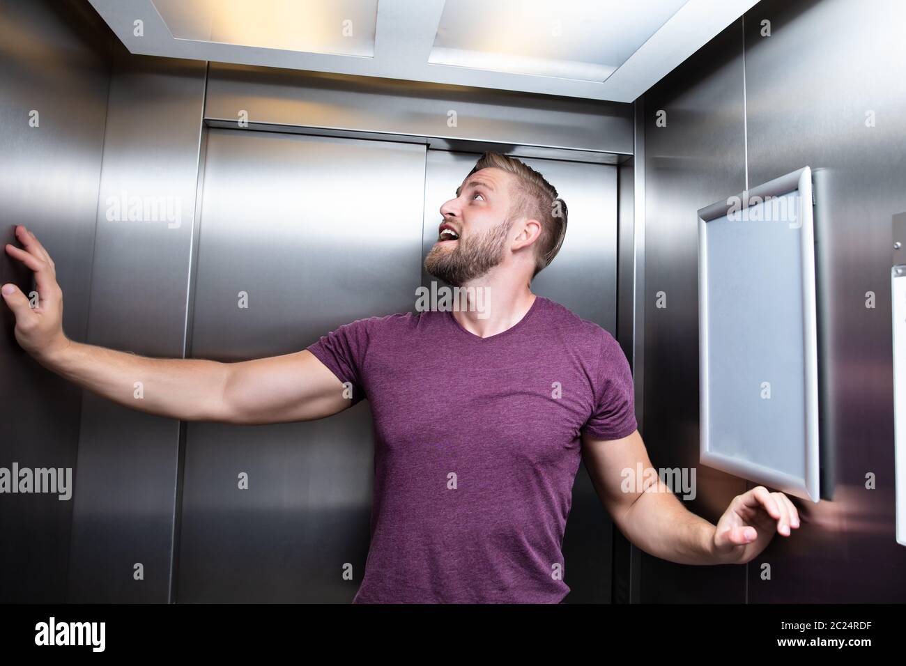 Man Suffering From Claustrophobia Trapped Inside Elevator Screaming Stock Photo