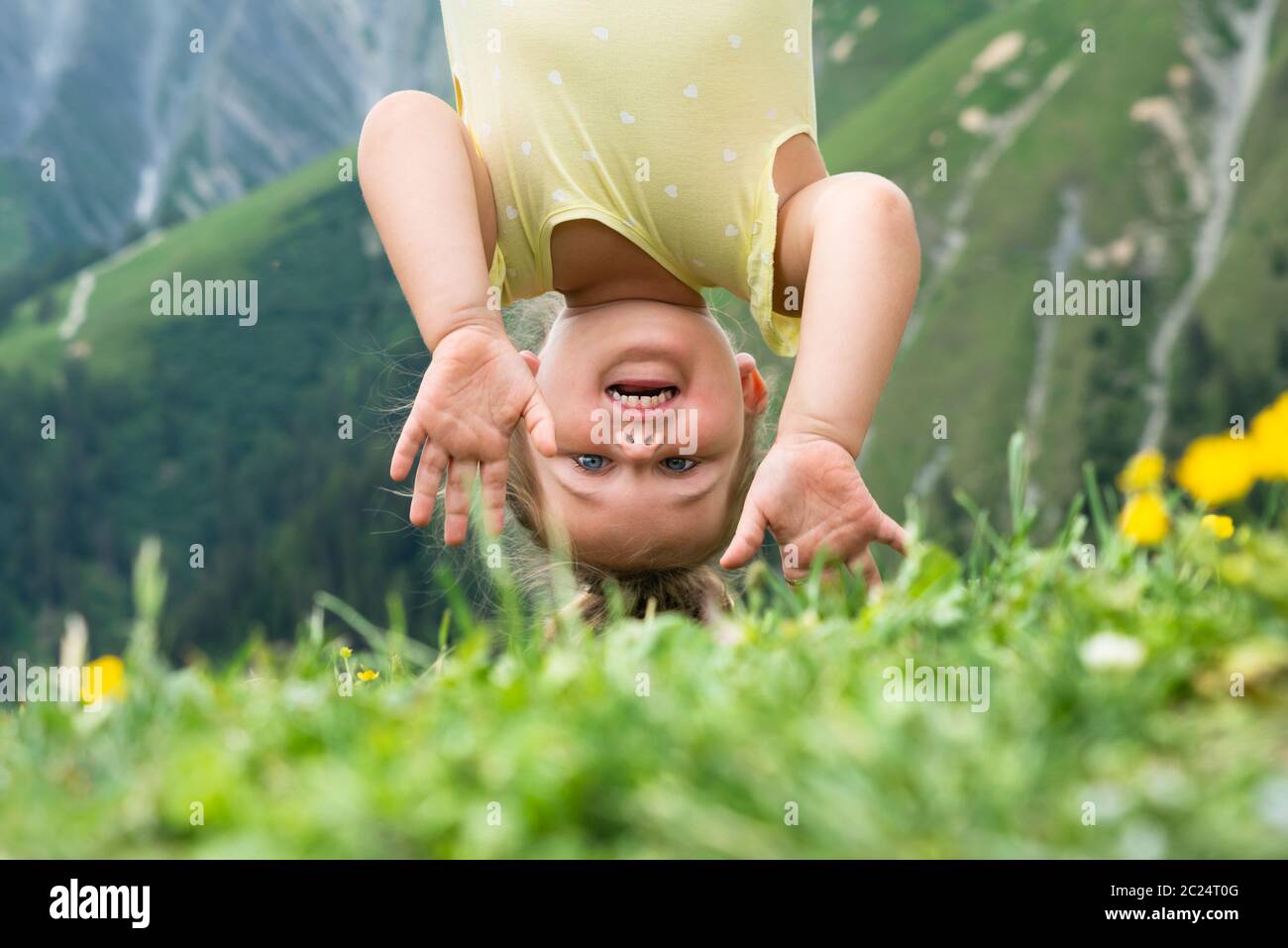 Little Girl Hanging Upside Down In Mountains Stock Photo