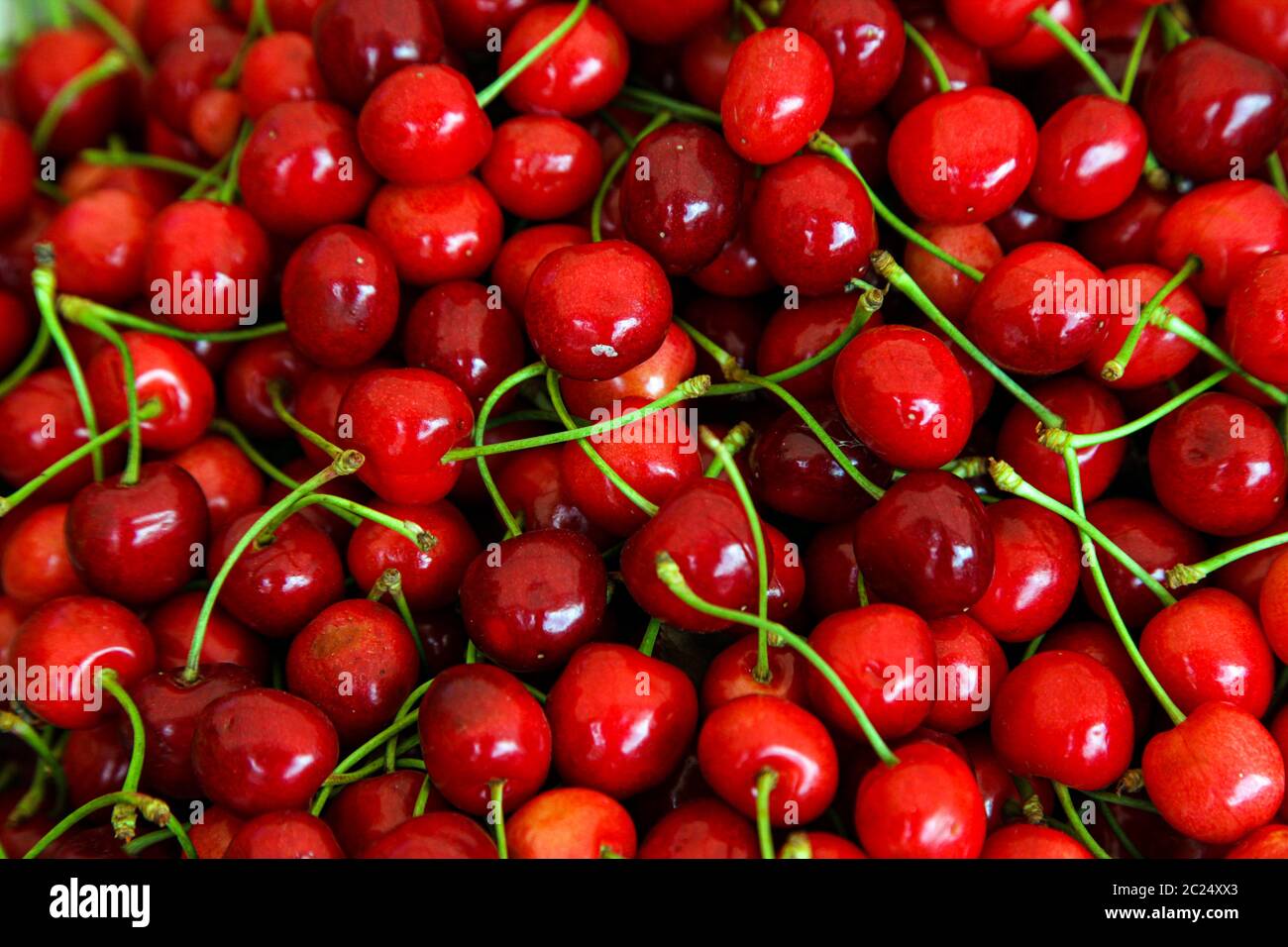 Red cherries with green stems, top view Stock Photo