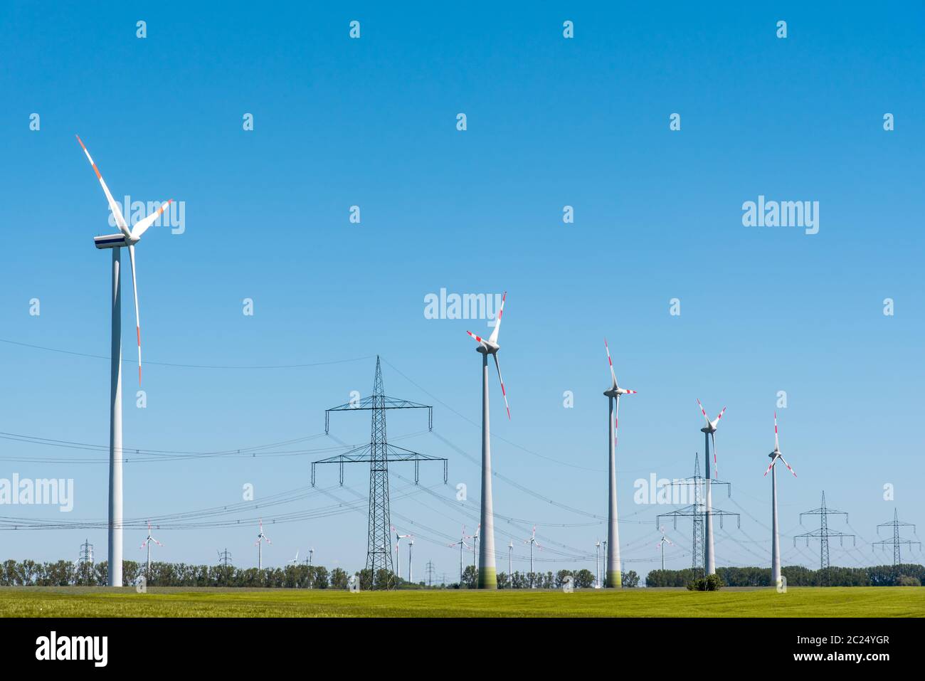 Wind energy plants and an overhead power line seen in Germany Stock Photo