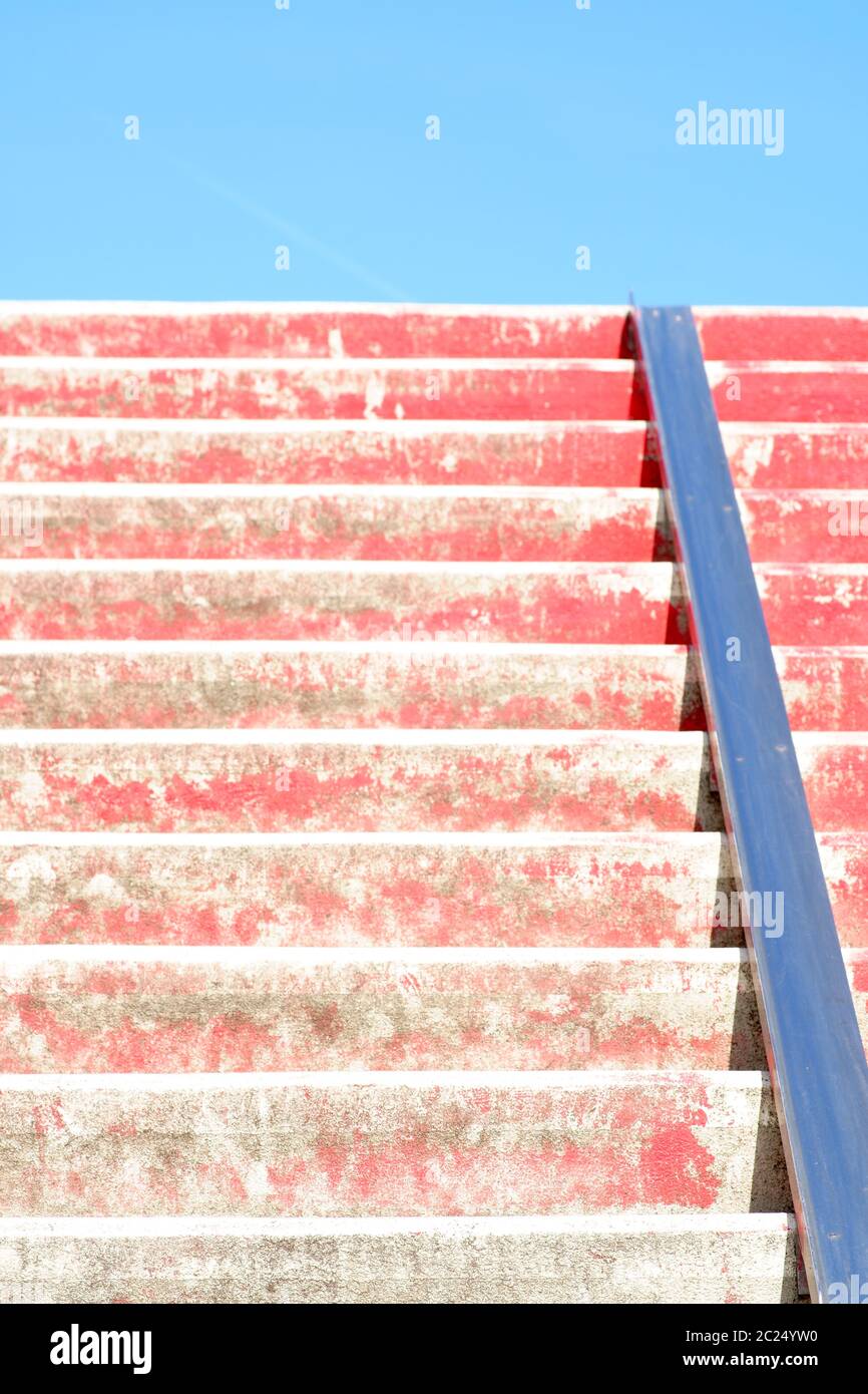 The closeup of red stairs with a bicycle rail. Stock Photo