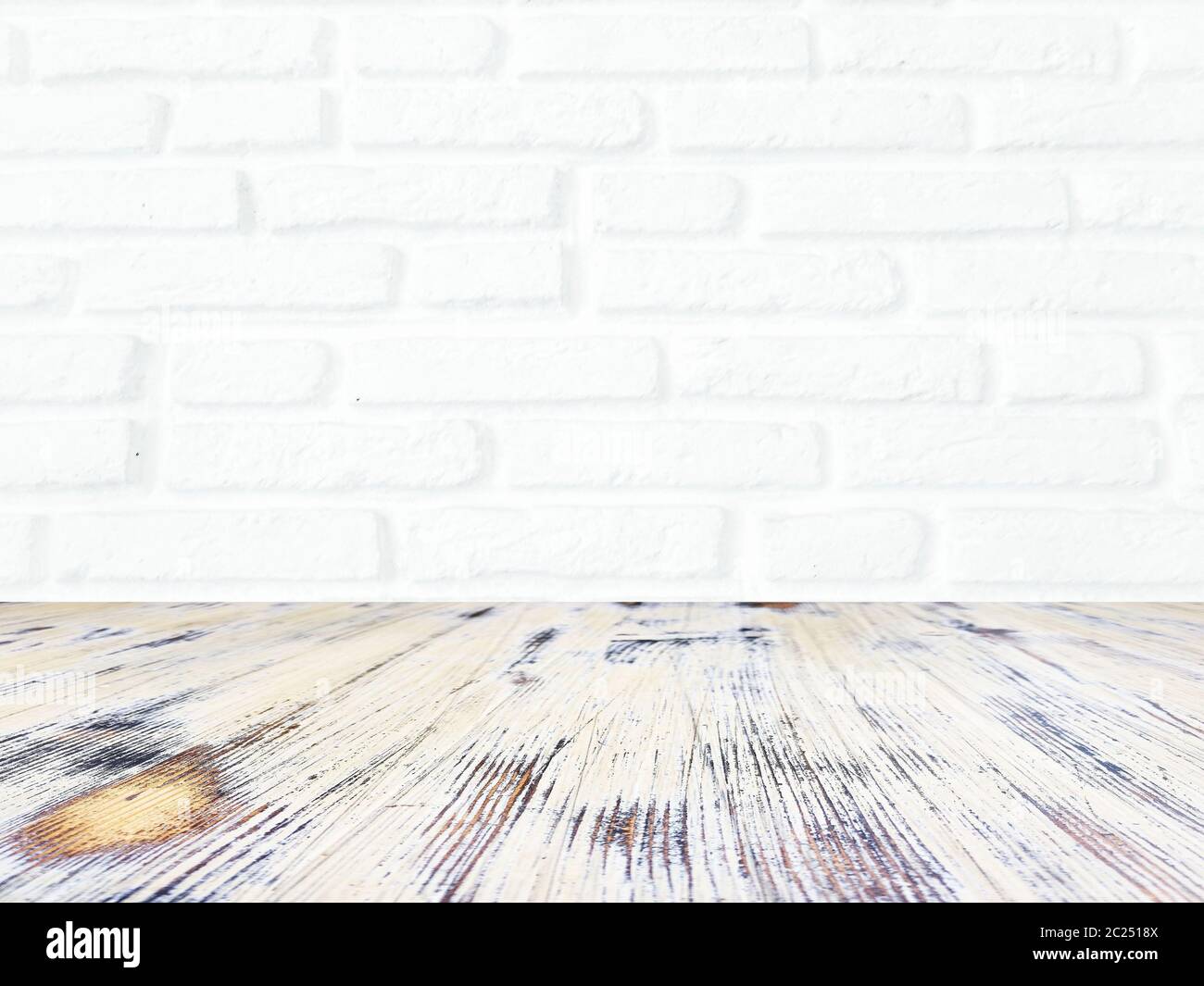 washed wood table with white brick wall texture background. Stock Photo