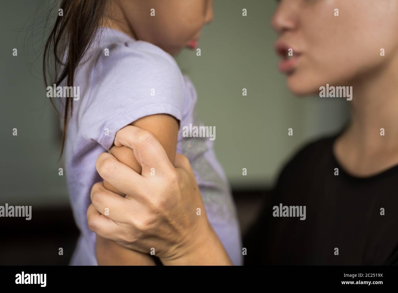 Upset stressed mother grabbing her child yelling at her. Bad parenting. Stock Photo