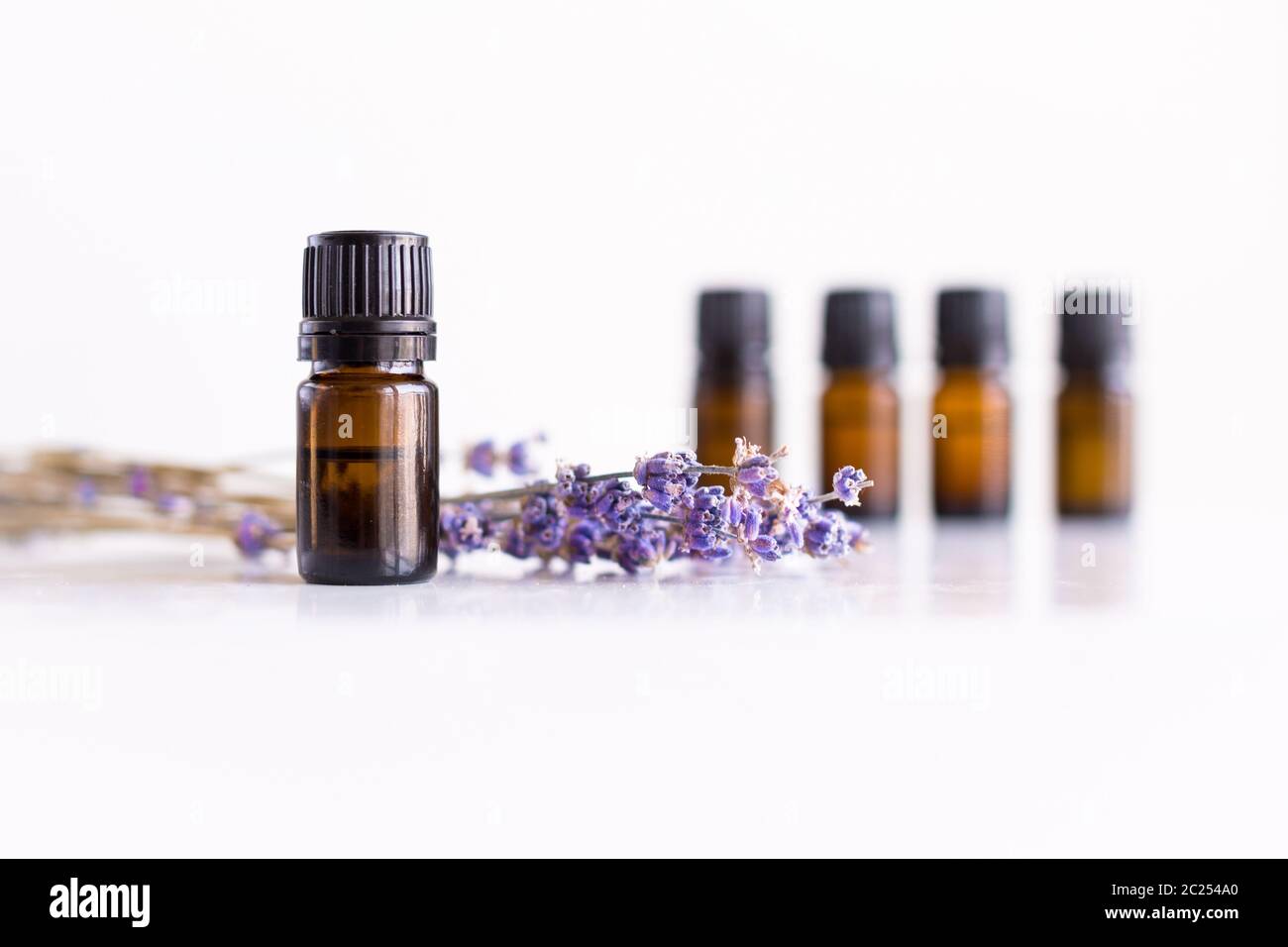 A row of essential oil bottles with lavender flowers and white ...