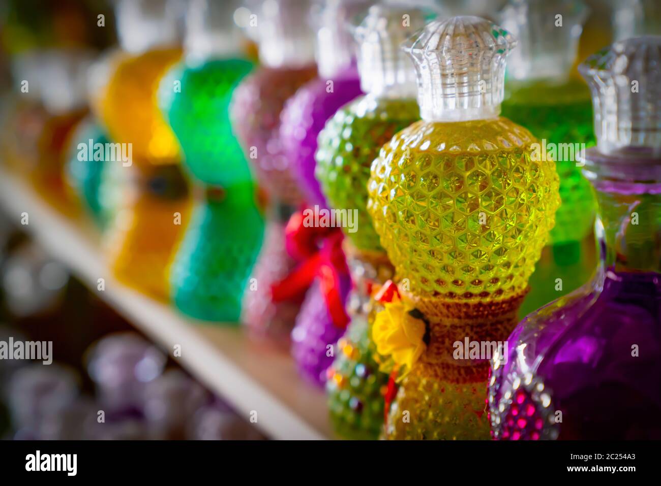 Gift cologne bottles in different colors with selective focus. Stock Photo
