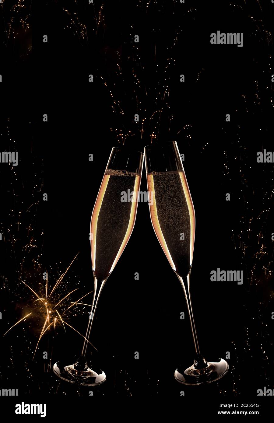 Golden champagne with fireworks on night sky for a vertical new year background Stock Photo