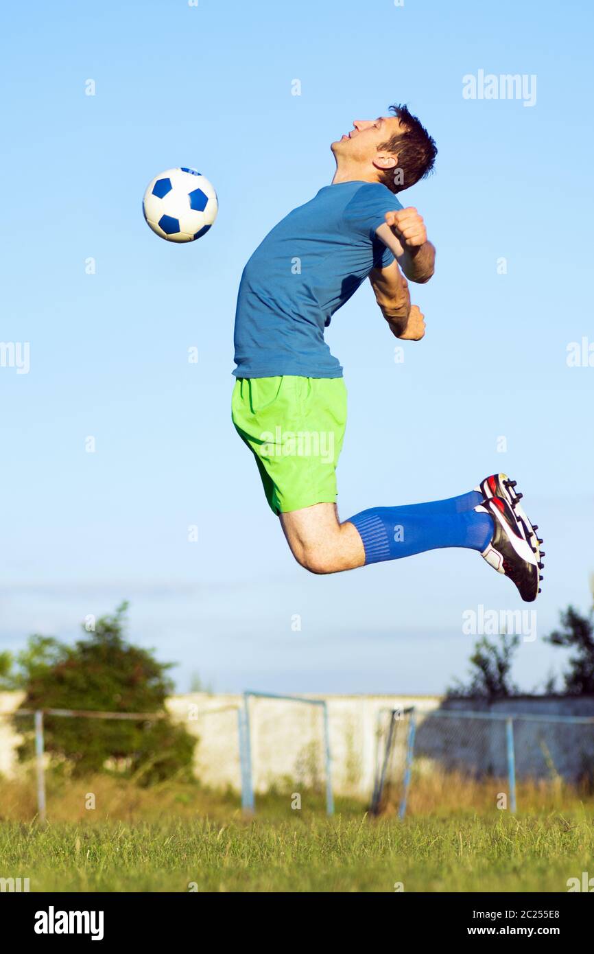 The soccer player is jumping to hitting soccer ball with chest, sport