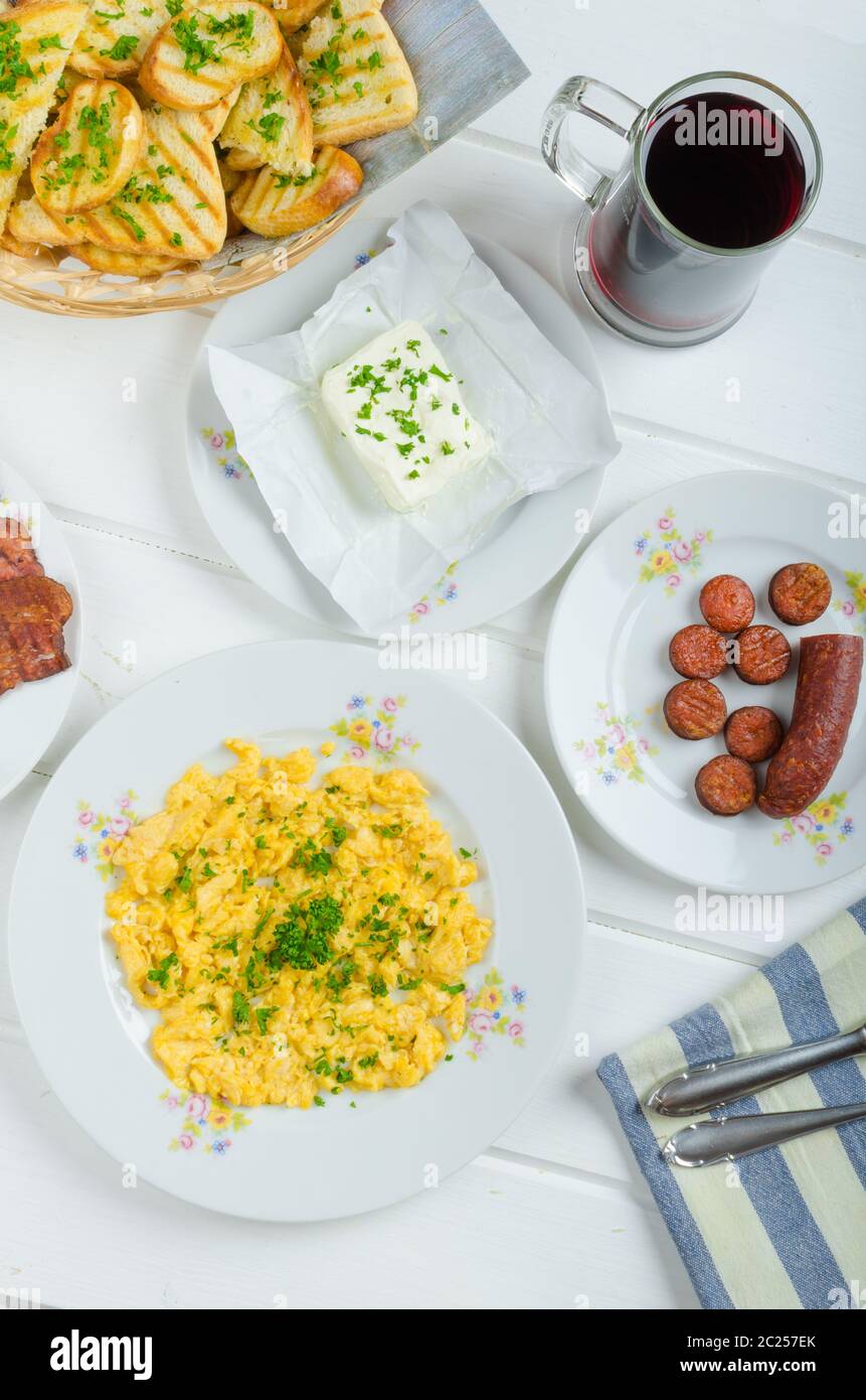 A hearty breakfast of eggs, bacon, sausage and toasted baguette and