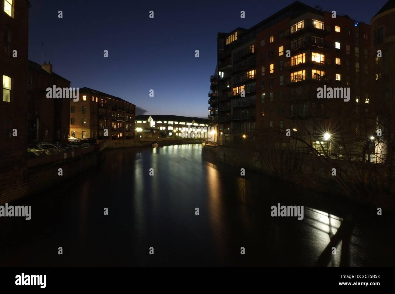 the river aire in leeds at night with illuminated windows in apartment ...