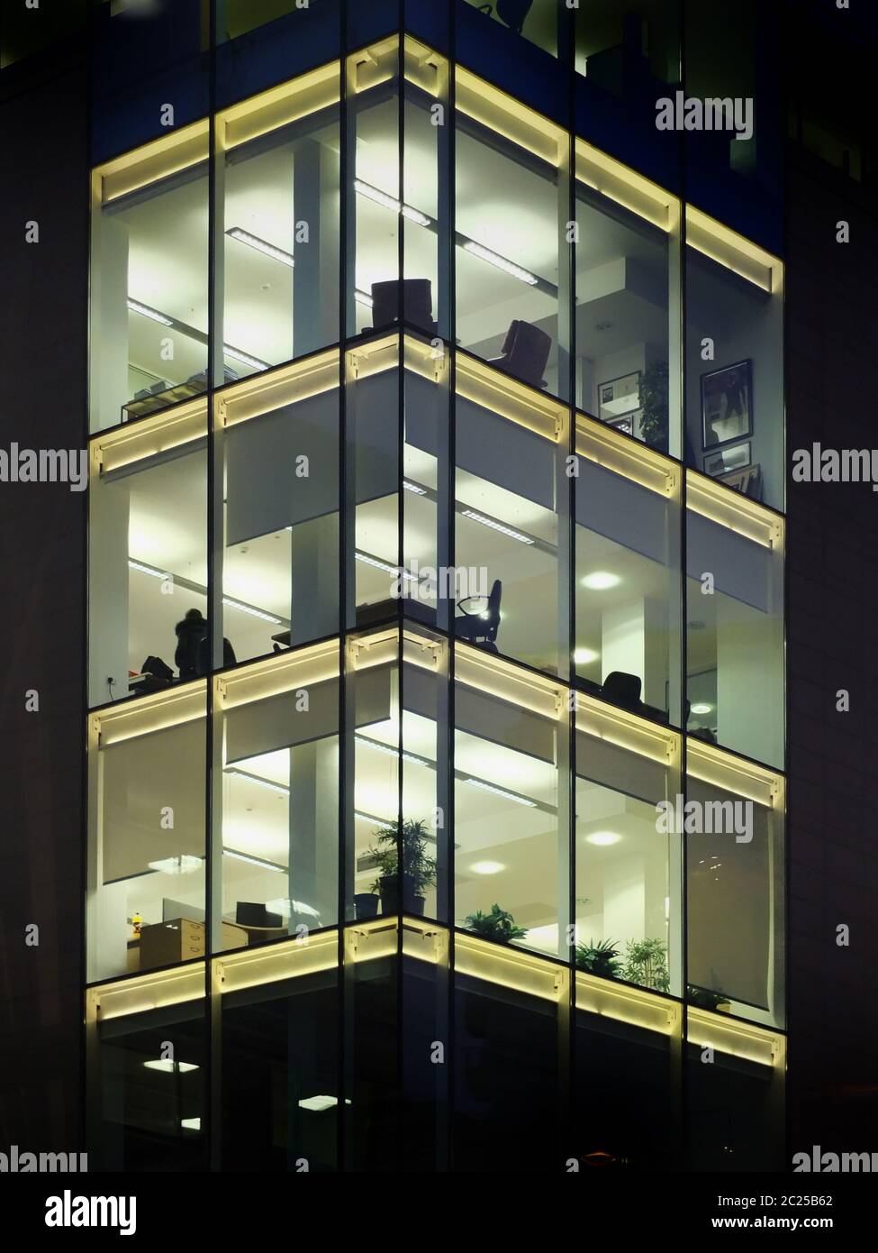 modern office building illuminated at night with geometric windows Stock Photo