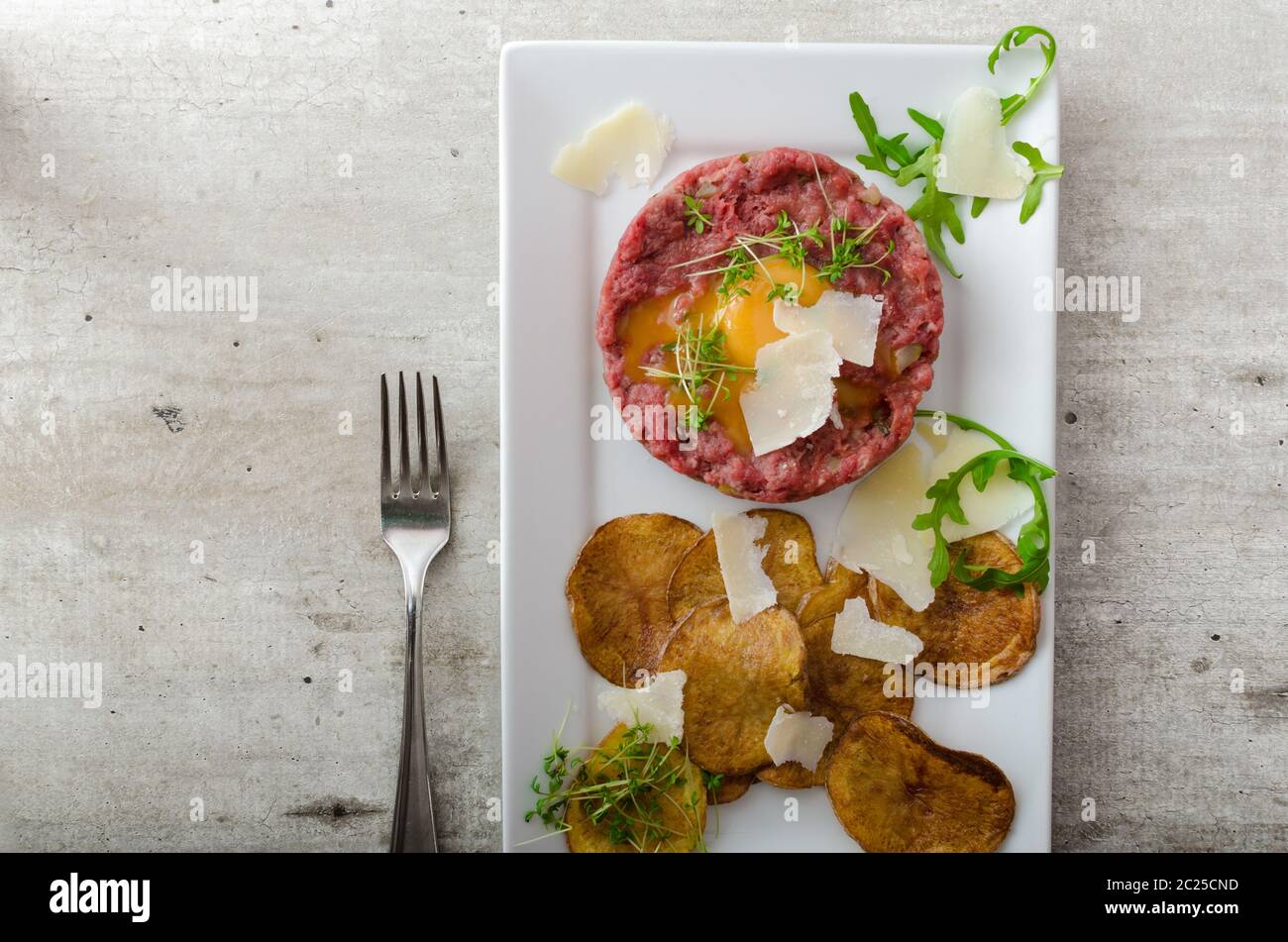 Beef tartar, homemade potato chips, sprinkled with parmesan shavings