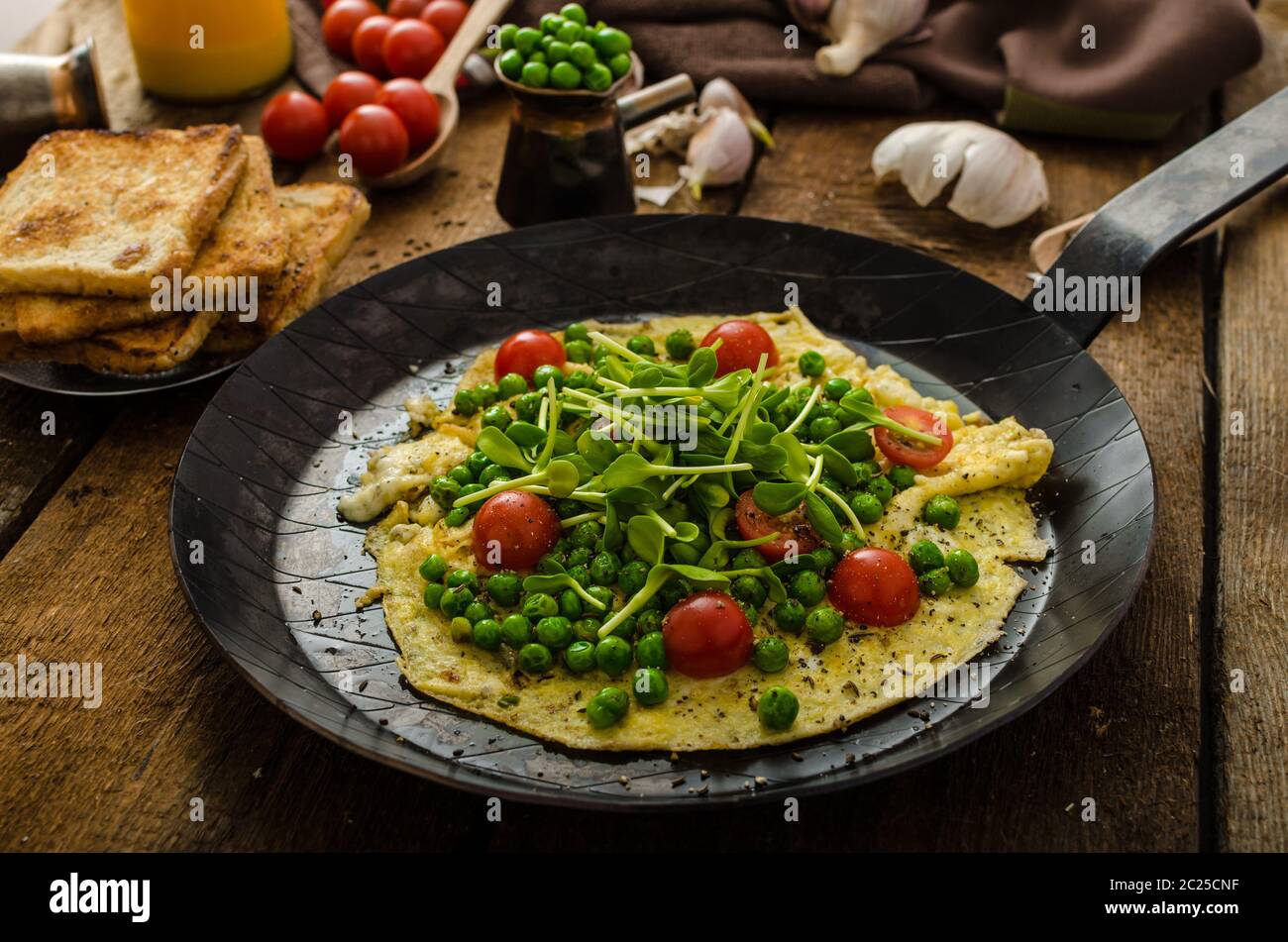Healthy omelet with vegetables peas and sunflower microgreens, cherry