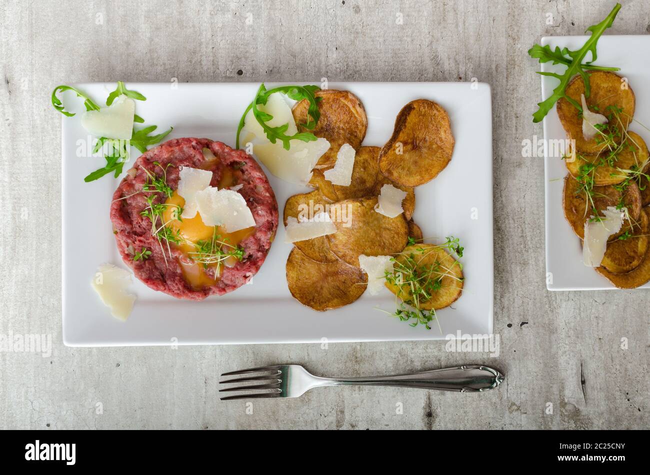 Beef tartar, homemade potato chips, sprinkled with parmesan shavings