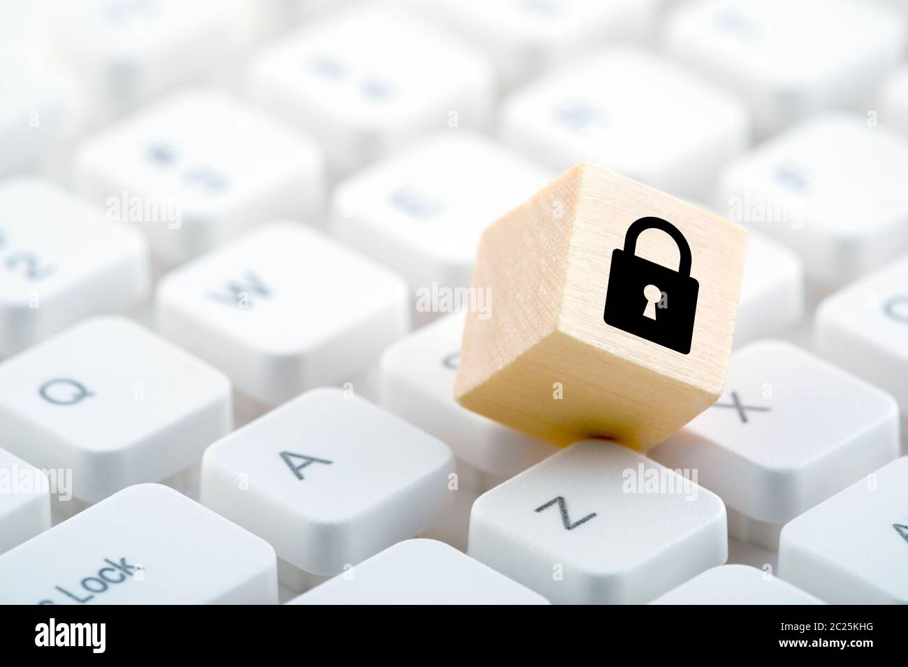 Wooden block with lock graphic on computer keyboard. Computer security concept. Stock Photo