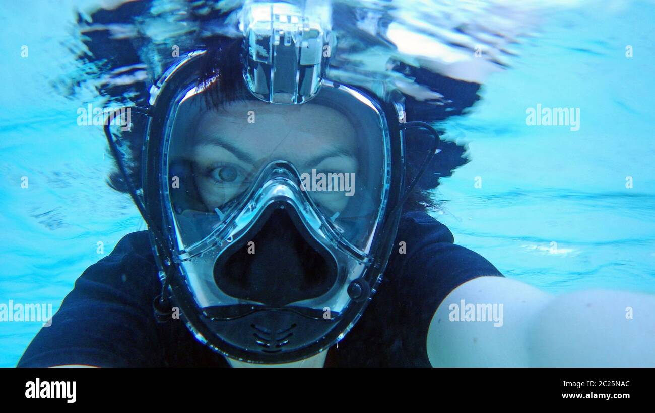 A young woman with a diving mask snorkeling in the sea Stock Photo