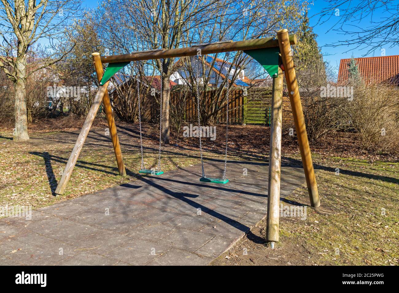 Swing on a deserted playground in late autumn Stock Photo