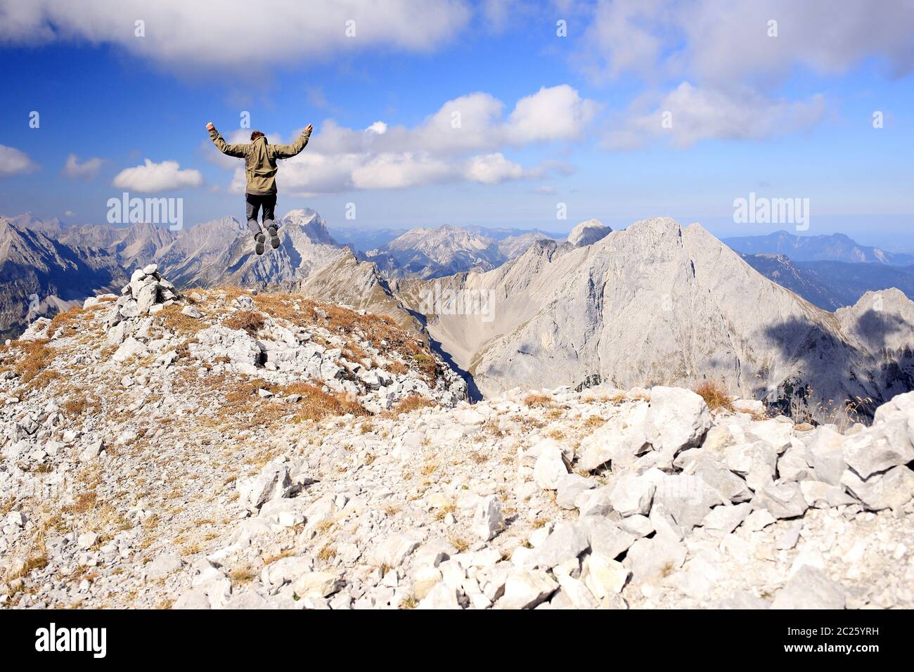 happy mountain hiker is jumping on the top of a mountain Stock Photo ...