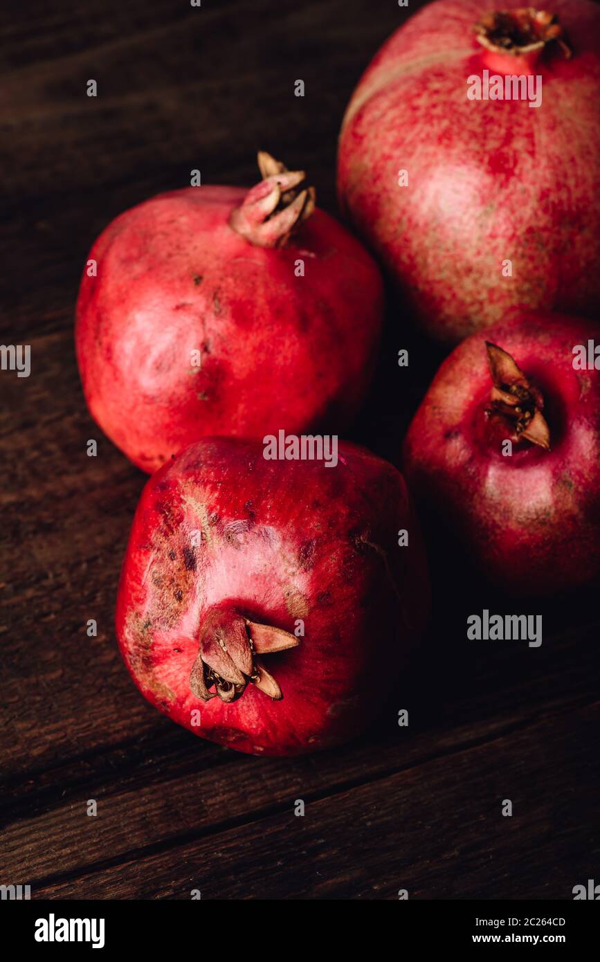 Four ripe pomegranate on rustic wooden table Stock Photo