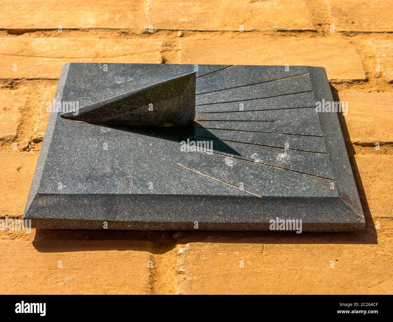 Granite Sundial - sun clock on orange brick floor Stock Photo - Alamy