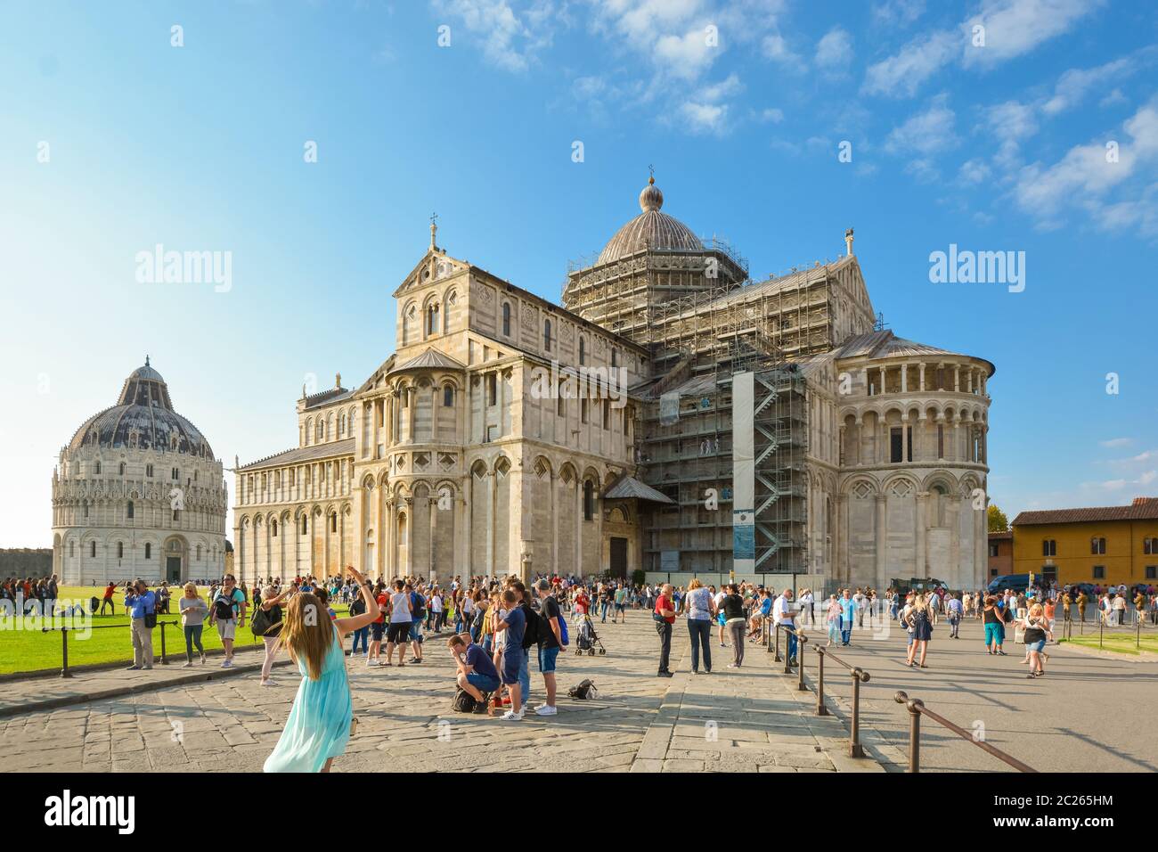 Tourists pose in front of the Pisa Duomo cathedral in the main piazza near the Leaning Tower in Pisa, Italy Stock Photo