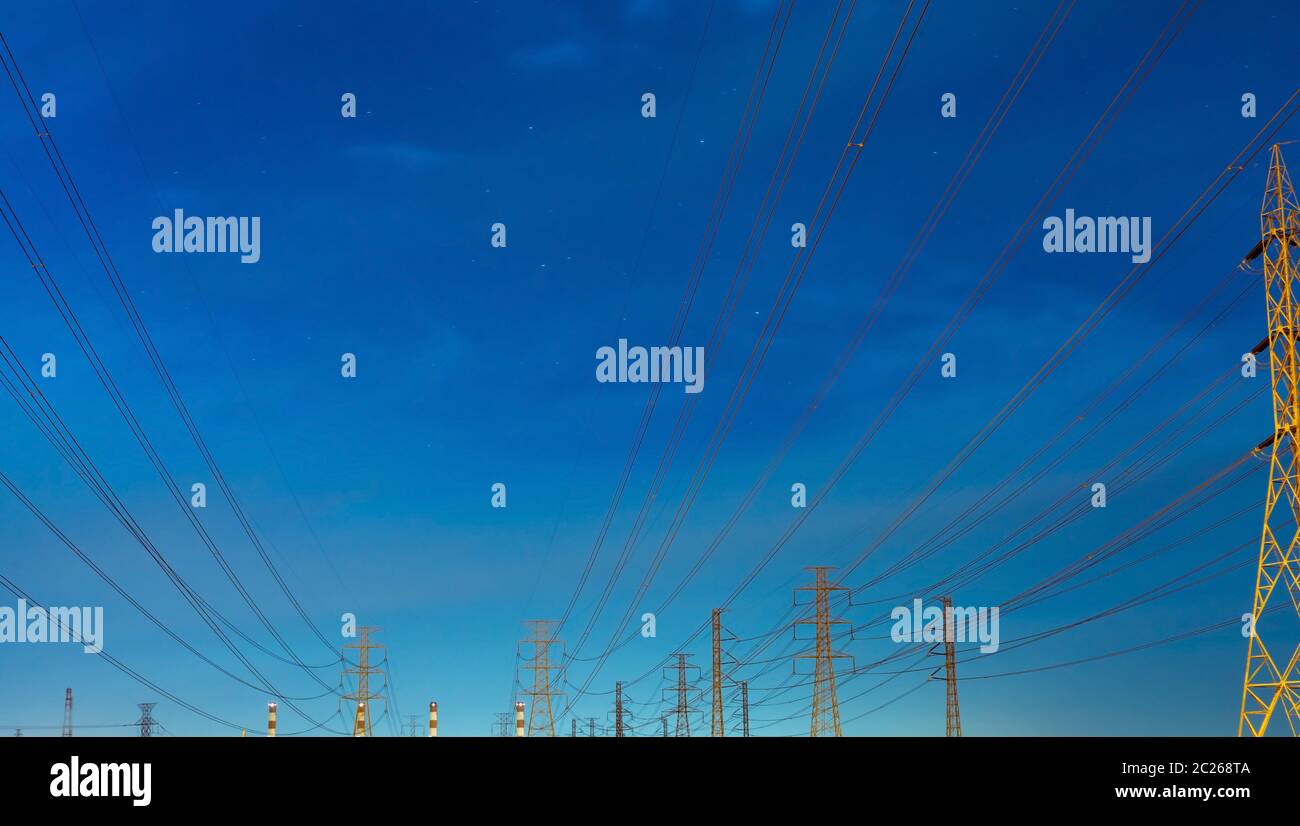 High voltage electric pole and transmission lines in the evening ...