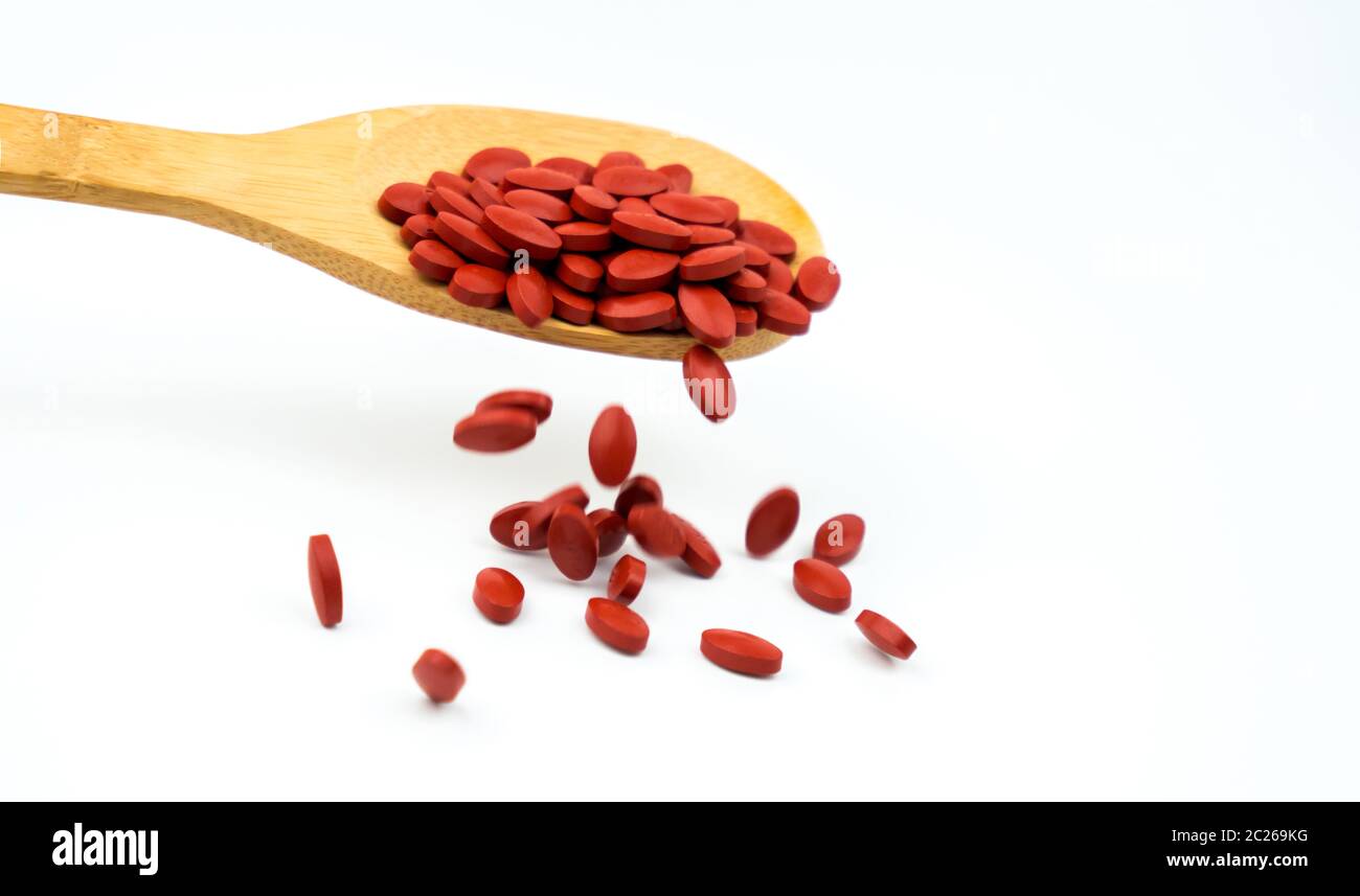 Iron tablets in spoon isolated on white background with copy space for