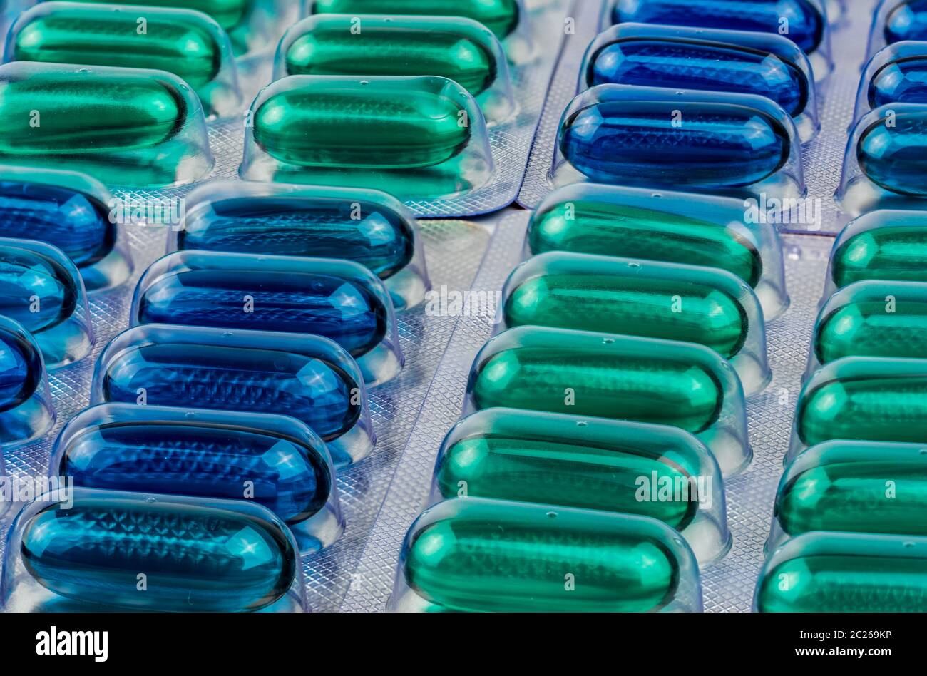 Macro shot detail of blue and green soft gel capsule pills in blister