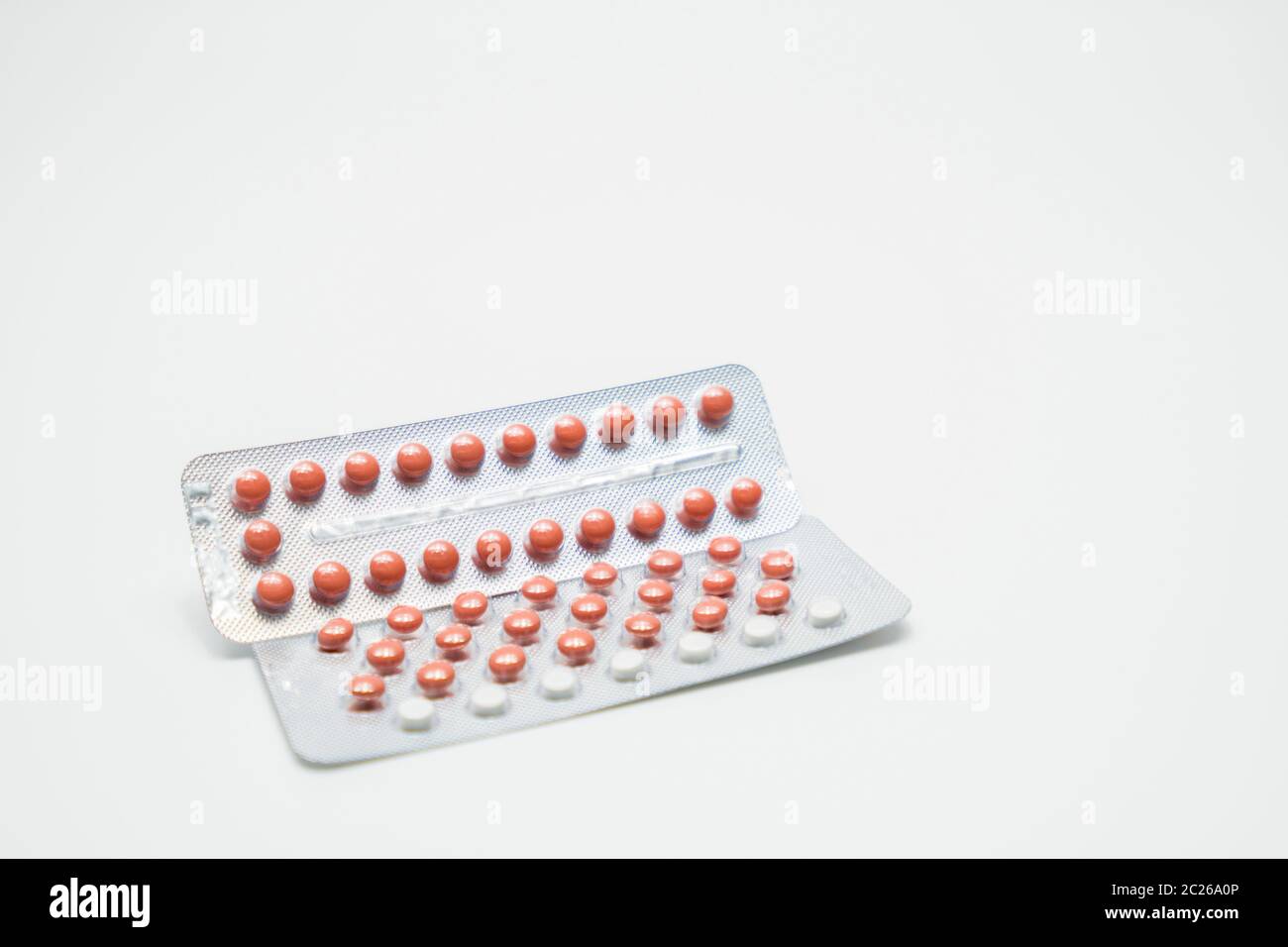Contraceptive pills in blister pack on white background. Birth control pills 21 and 28 tablets. Hormones tablet pills. Pharmacy drugstore background. Stock Photo