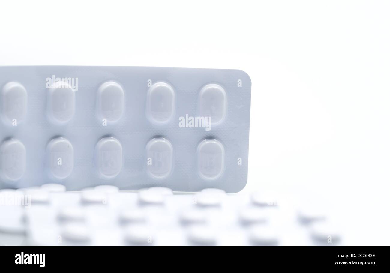 Macro shot detail of tablets pill in white blister pack for light resistance packaging isolated on white background. Medicine for treatment NCDs. Elde Stock Photo