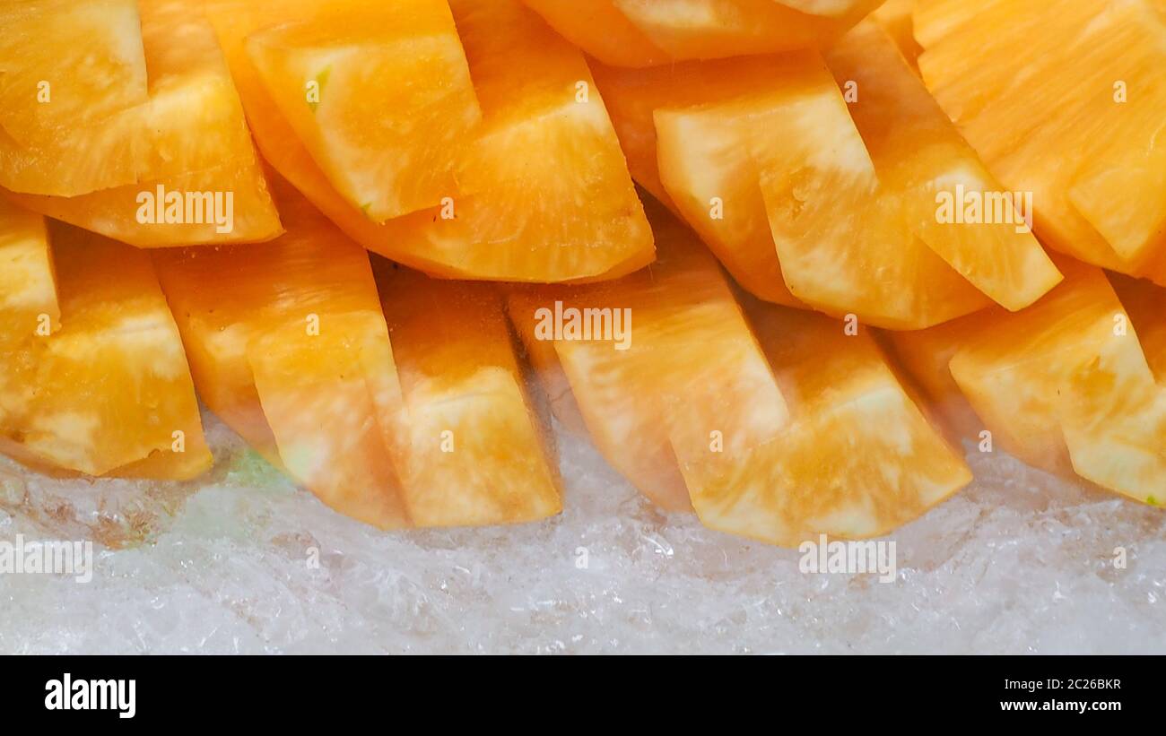Orange or yellow pineapple sliced on crushed ice. Tropical fruit